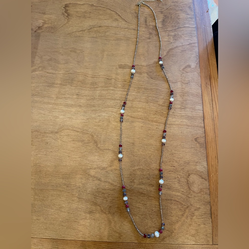 Gold beaded necklace with pearl, lavender, gray and red beads.